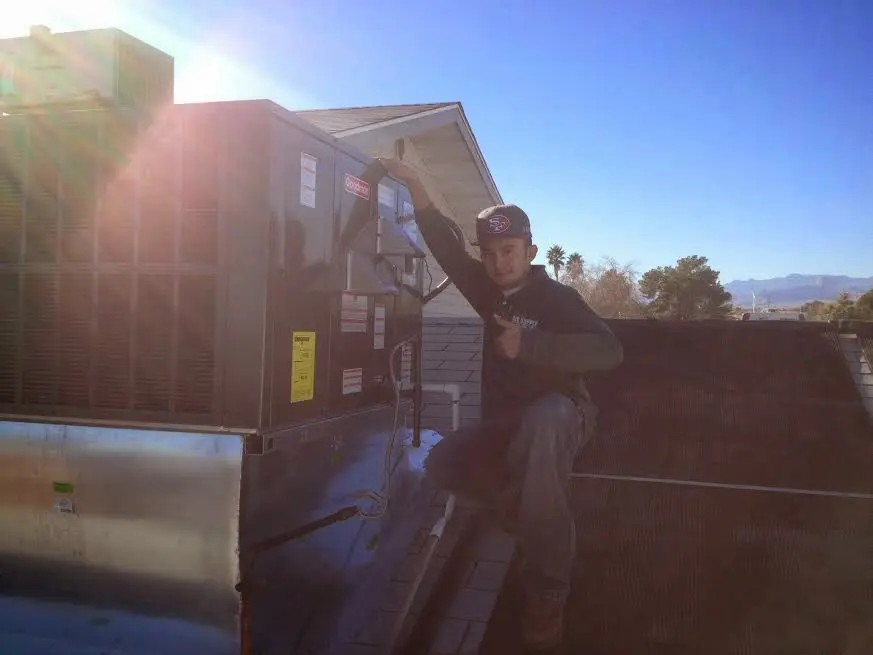 HVAC technician performing Heat Pump Repair on a rooftop unit in Lower Heidelberg